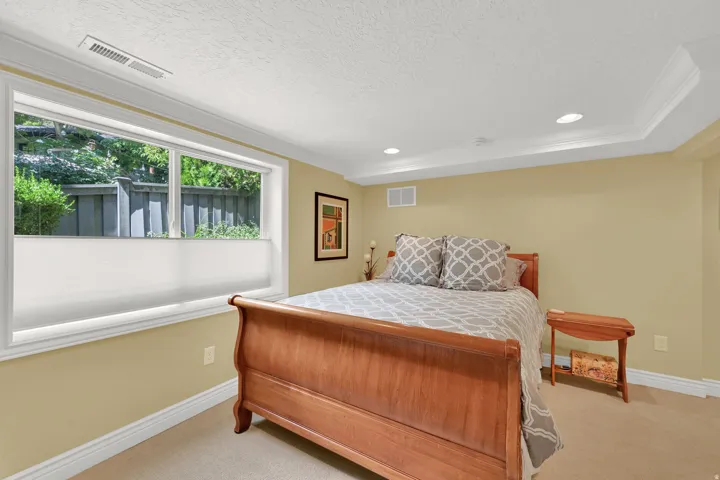 Recessed lighting, crown molding, wall-to-wall carpeting, and a wide window
