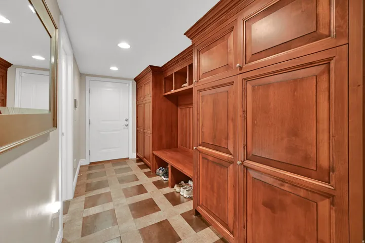 Built-in cabinetry with crown molding, integrated bench seating, and recessed lighting