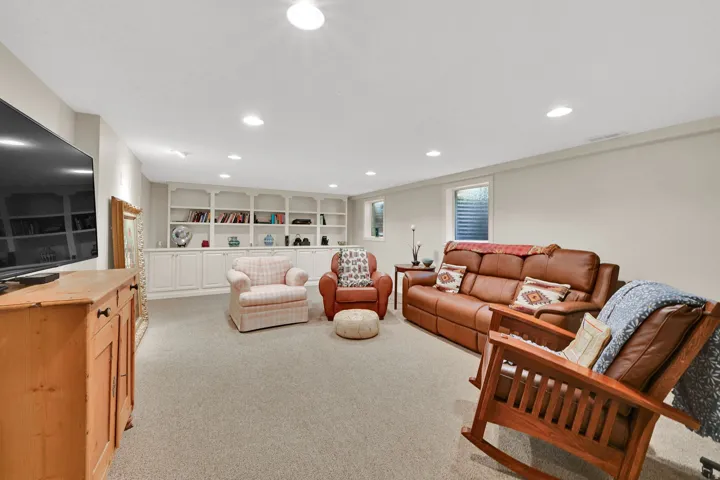 Recessed ceiling lighting, built-in shelving, built-in cabinetry, and neutral wall tones