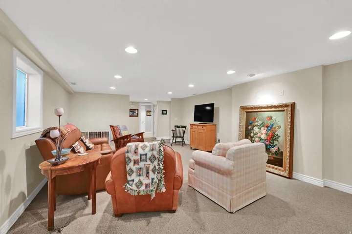 Recessed lighting, window with white trim, light-colored walls, and carpet flooring