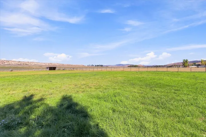 Expansive grassy field with a distant building structure