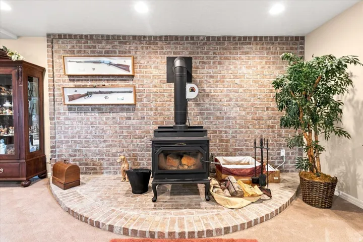 Brick-clad accent wall with an integrated wood-burning stove and a matching brick hearth