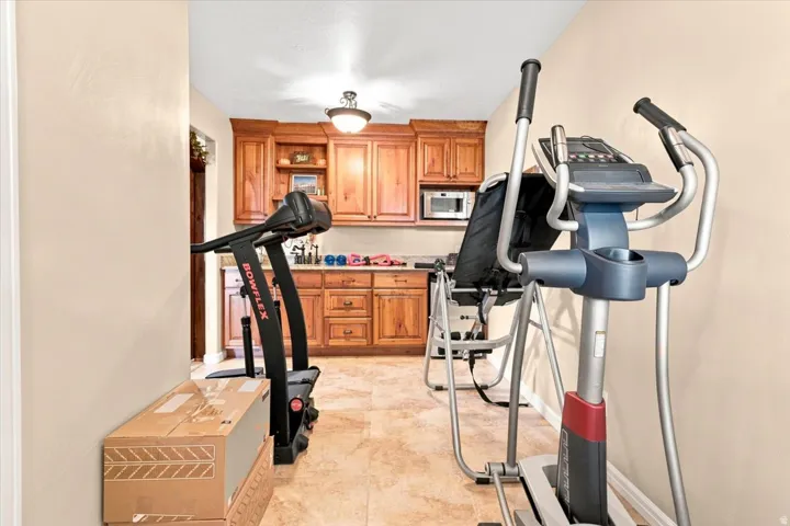 Built-in wood cabinetry, integrated microwave, recessed lighting, and tile flooring