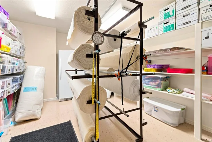 Built-in shelving, white refrigerator, light-toned flooring, and overhead lighting
