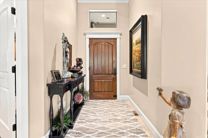Warm wood-paneled door with white trim and transom window
