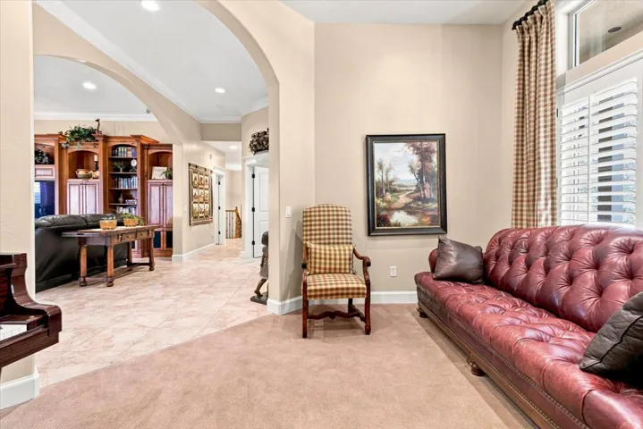 Arched doorways open to a space featuring a built-in wood-finish entertainment center
