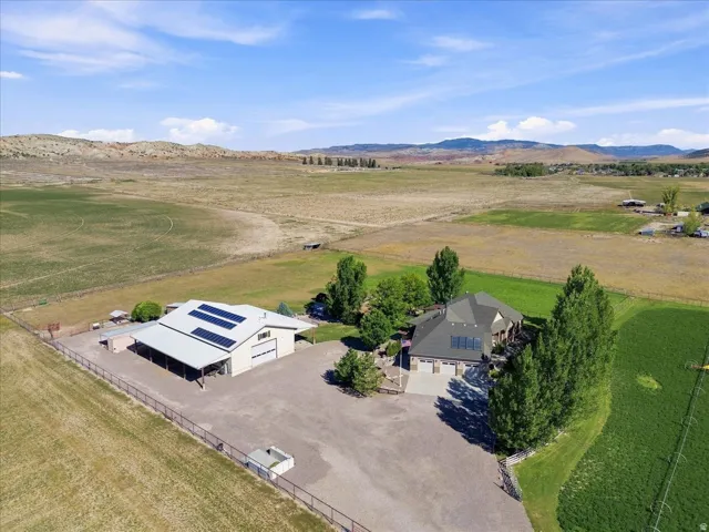 Expansive property featuring a residence, detached auxiliary building with solar panels, and a large paved drive