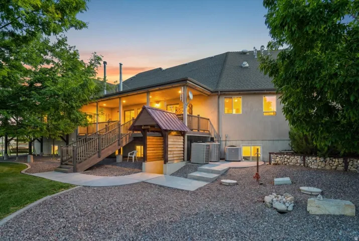 Expansive rear deck with railing, covered porch, and exterior staircase