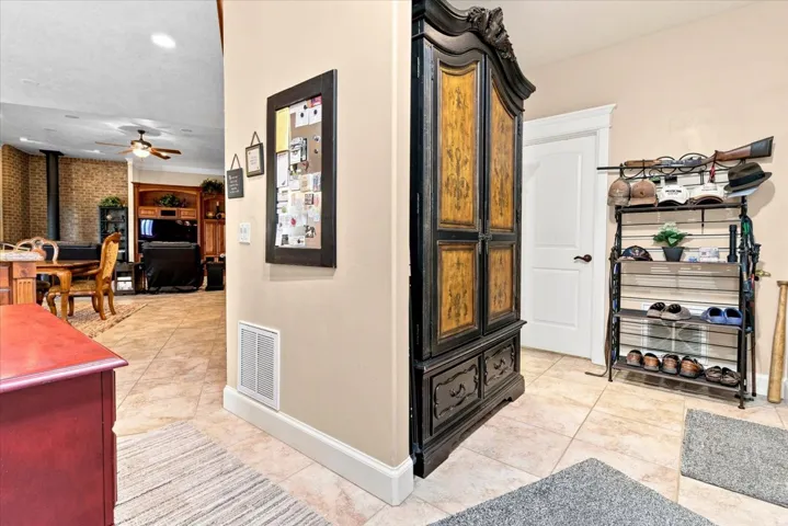 Neutral tone wall, recessed lighting, and tile flooring
