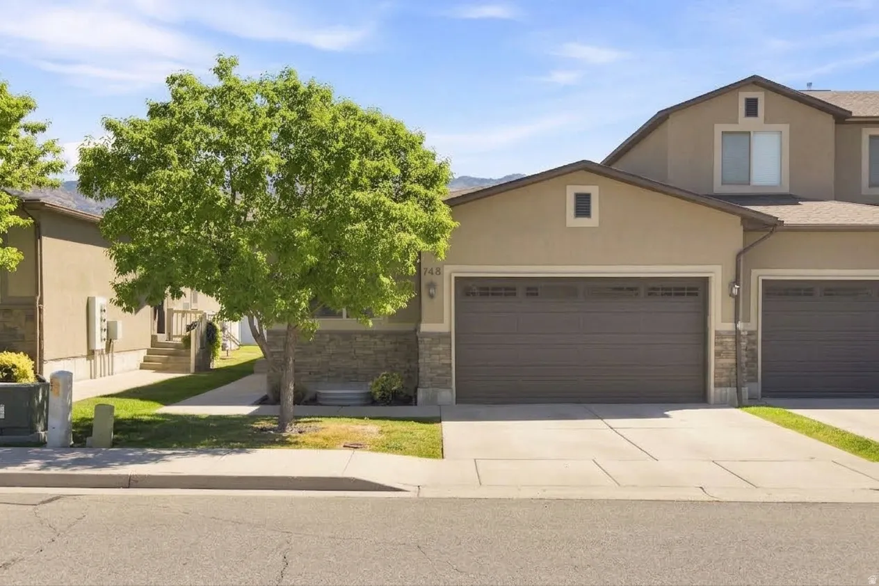 Stucco exterior with stone accents, 2-car garage.