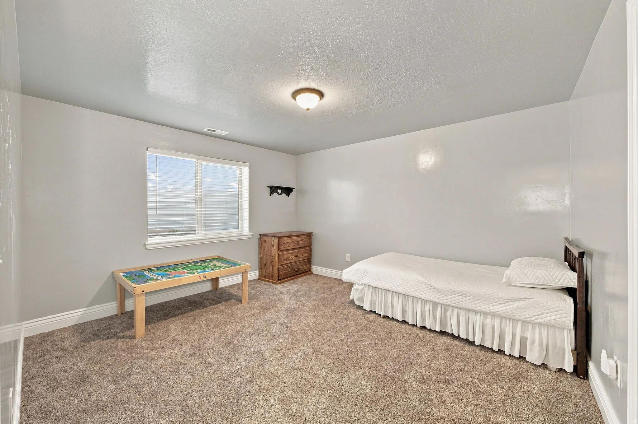 Neutral wall tones, recessed window, and textured carpeting