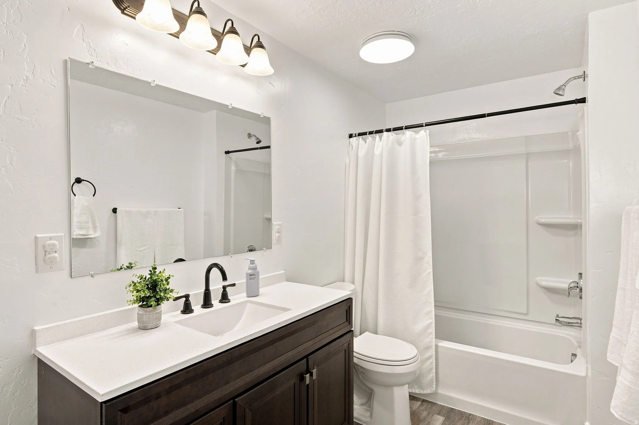 Dark wood-finish vanity with white countertop and integrated sink