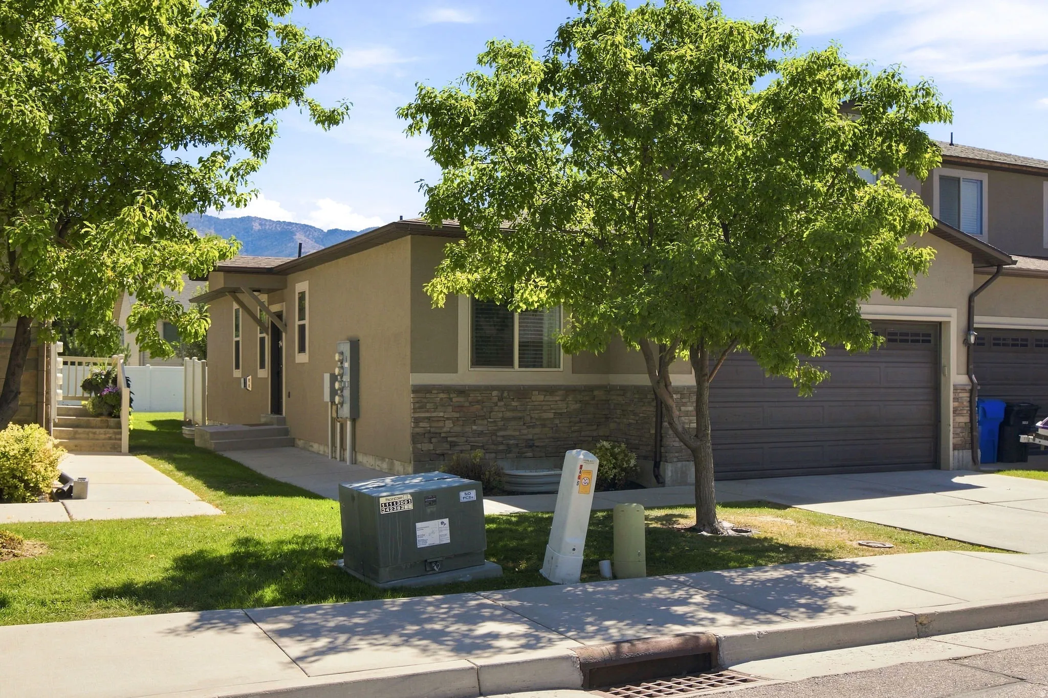 Stucco exterior with stone accents, and an attached garage