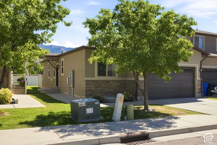 Stucco exterior with stone accents, and an attached garage