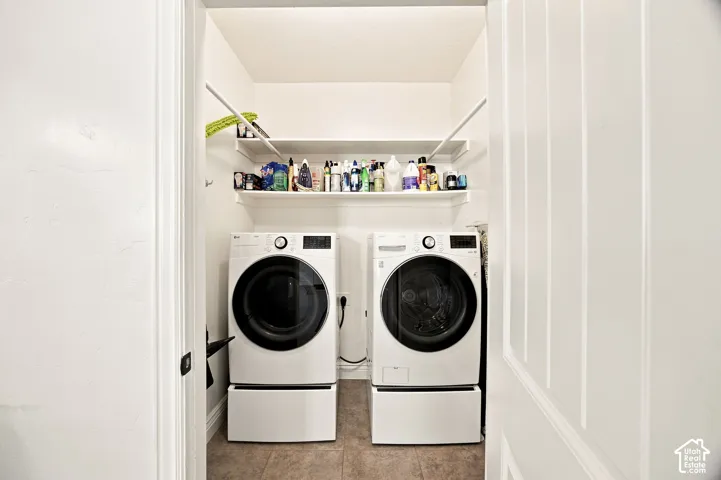 Laundry area featuring two built-in shelves and tile flooring