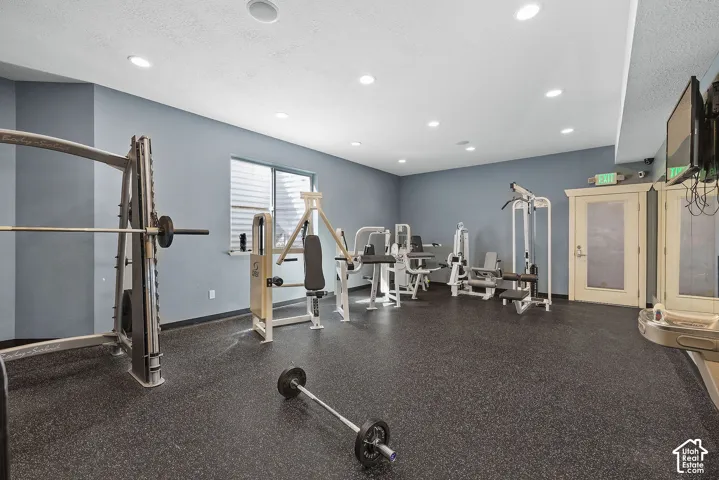 Weight fitness space featuring rubber flooring, recessed lighting, and a window with blinds