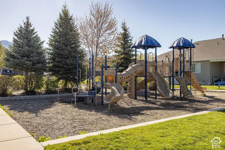 Community playground with a multi-level structure, slides, and shaded areas