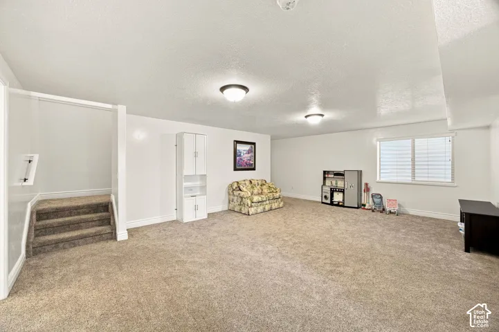 Spacious living room with carpet flooring, recessed window