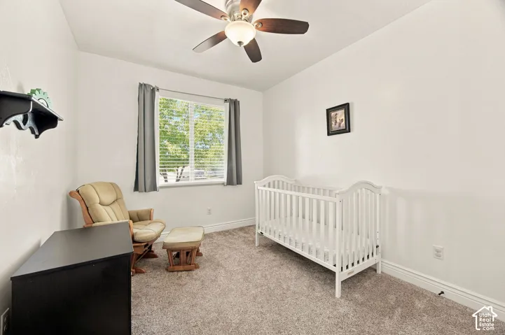 Room featuring a ceiling fan with integrated lighting, a window with blinds, and neutral carpeting