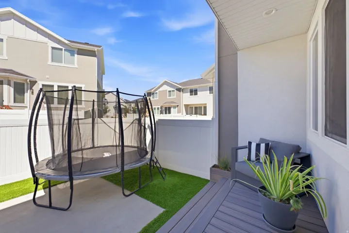 Private outdoor patio featuring composite decking, recessed lighting, and a stucco exterior wall