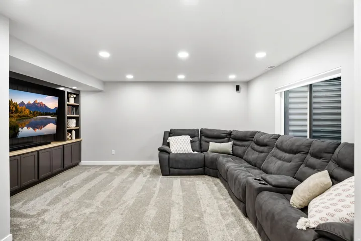 Built-in entertainment center with integrated shelving, dark cabinetry, and light wood-finish countertop