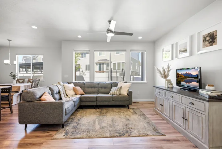 Open-concept living space with wood-finish flooring, recessed lighting, and multiple windows