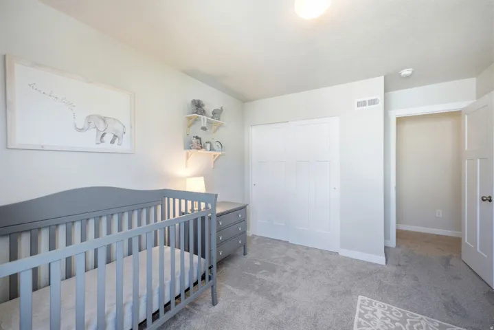 Neutral wall color, wall-to-wall carpeting, overhead lighting, white trim, and white sliding closet doors