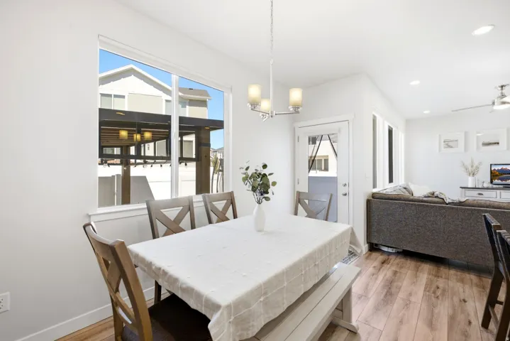 Open concept living space with wood-finish flooring, recessed lighting, and a modern chandelier