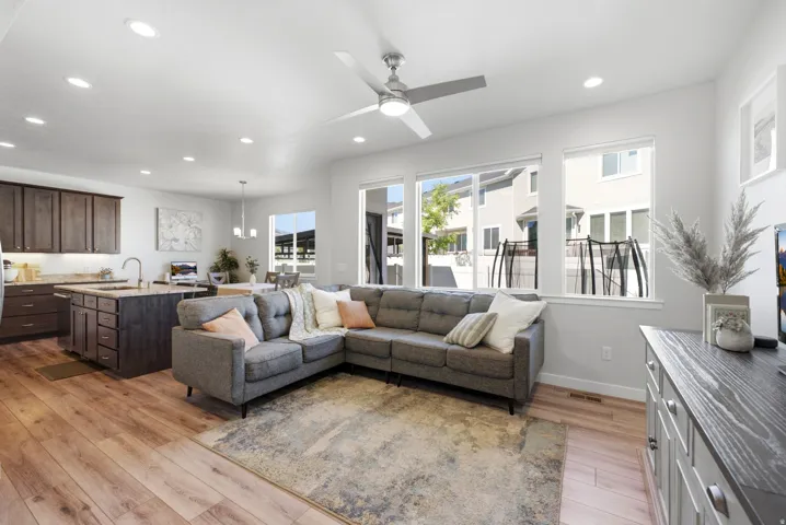 Open-concept living area featuring wood-finish flooring, recessed lighting, and a ceiling fan