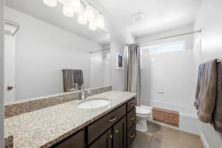 Expansive vanity with a light-toned countertop and dual undermount sinks, complemented by dark wood-finish cabinetry