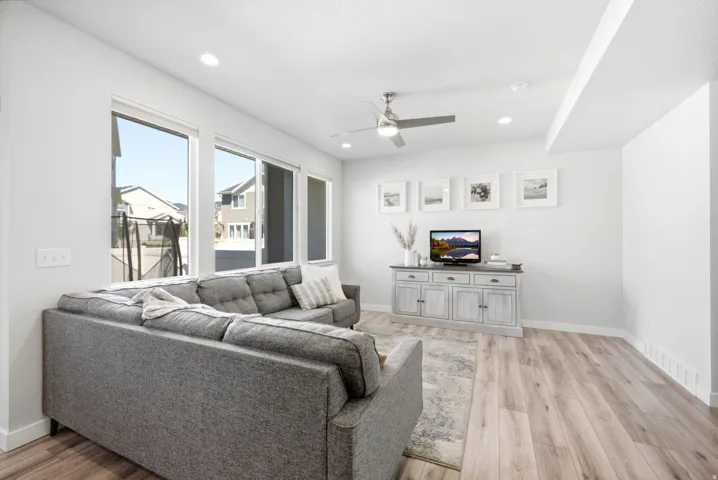 Open-concept living area featuring wood-finish flooring, recessed lighting, and a ceiling fan
