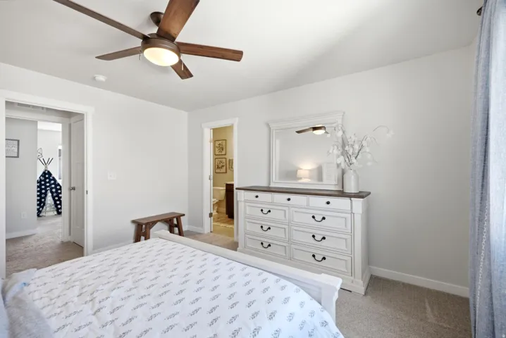 Carpeted flooring, white walls, and a ceiling fan with integrated lighting