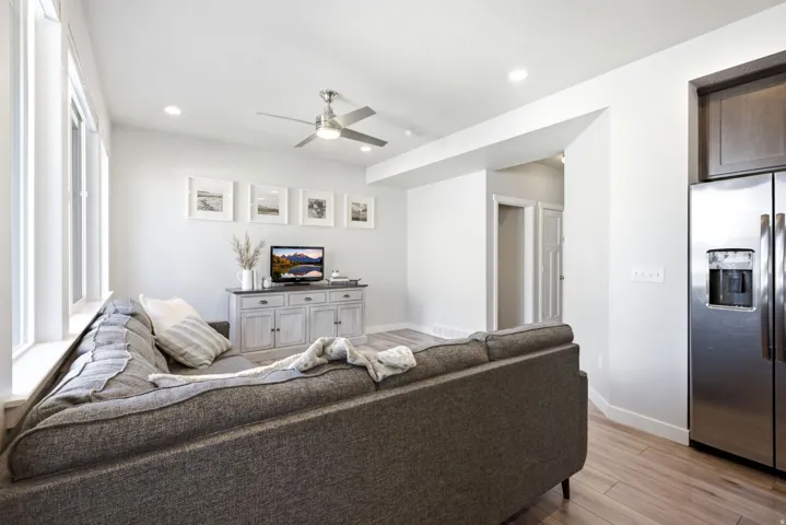 Recessed lighting, wood-finish flooring, stainless steel refrigerator, contemporary ceiling fan, and multiple windows