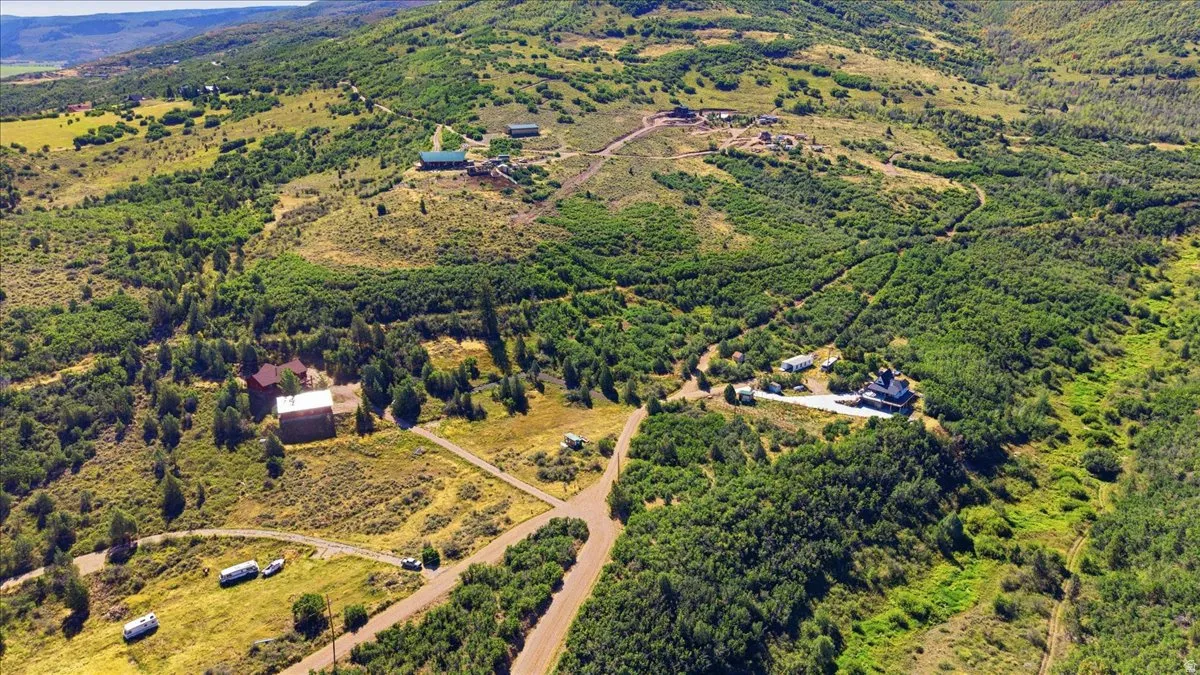 Expansive acreage featuring multiple structures, mature trees, and varied terrain