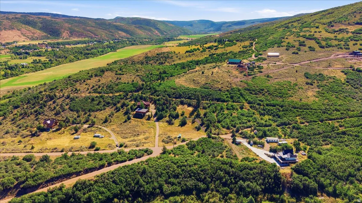 Expansive land featuring mountainous terrain, mature trees, and varied vegetation