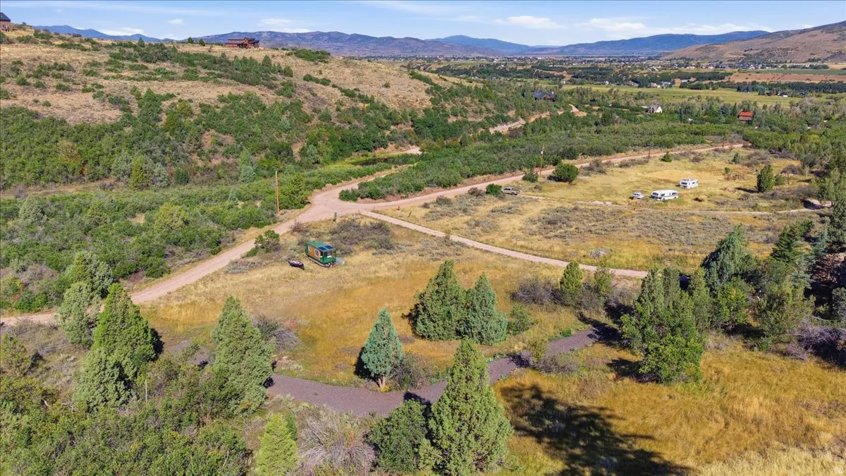 Expansive natural landscape with varied terrain, featuring extensive tree coverage and visible dirt roads