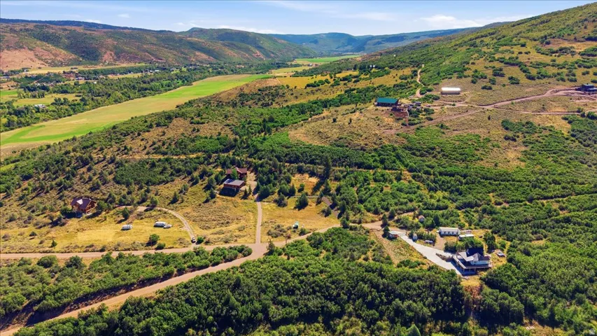 Expansive land featuring mountainous terrain, mature trees, and varied vegetation