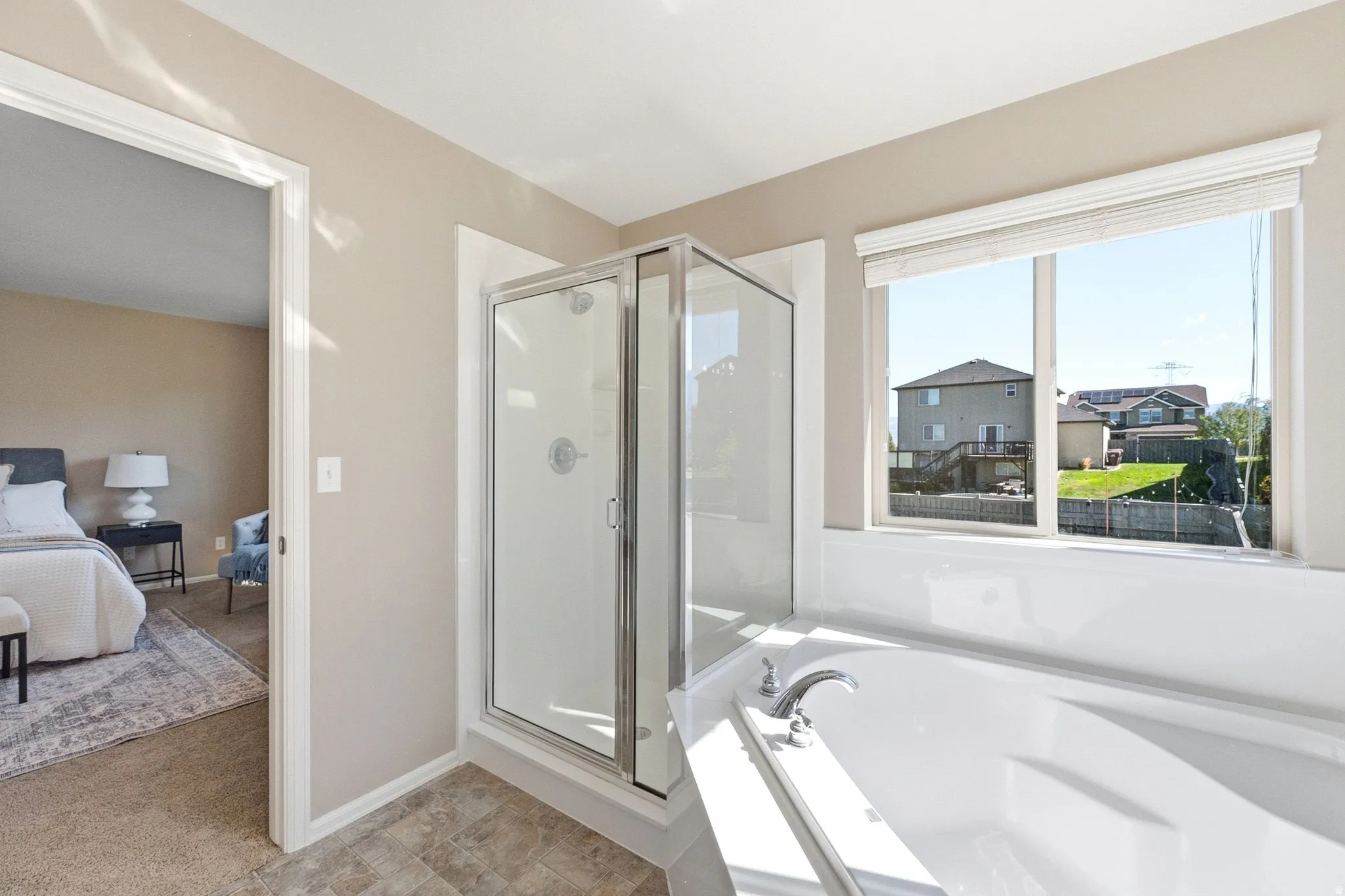 Built-in soaking tub, glass-enclosed shower, expansive window, and durable flooring