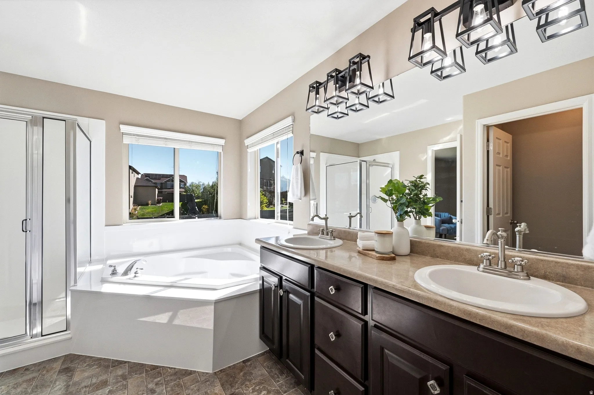Double vanity with undermount sinks, bronze cabinetry, and a full-width mirror