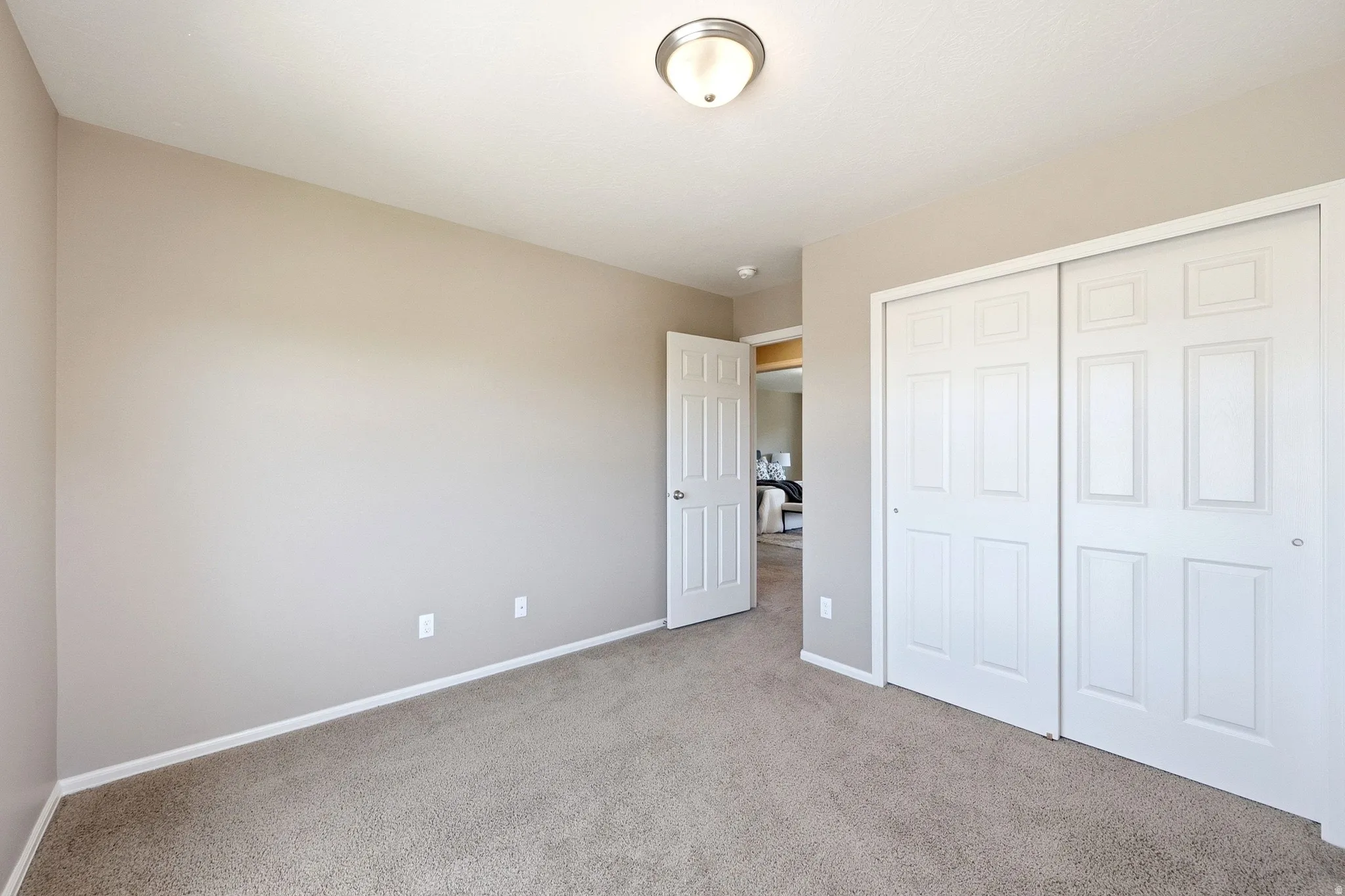 Neutral-toned walls complement the carpeted flooring