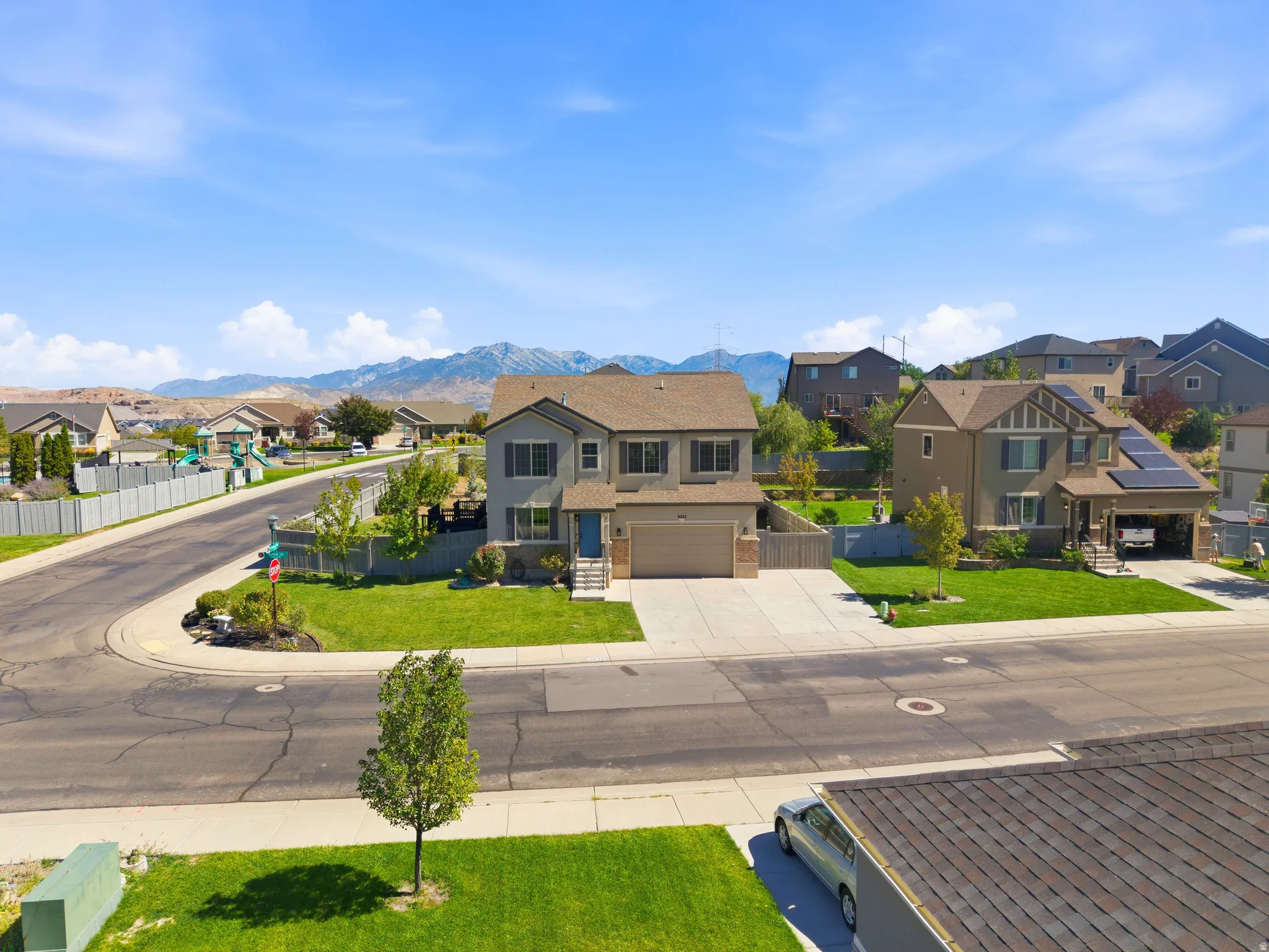 Two-story residence with an attached garage, paved driveway, and manicured front lawn