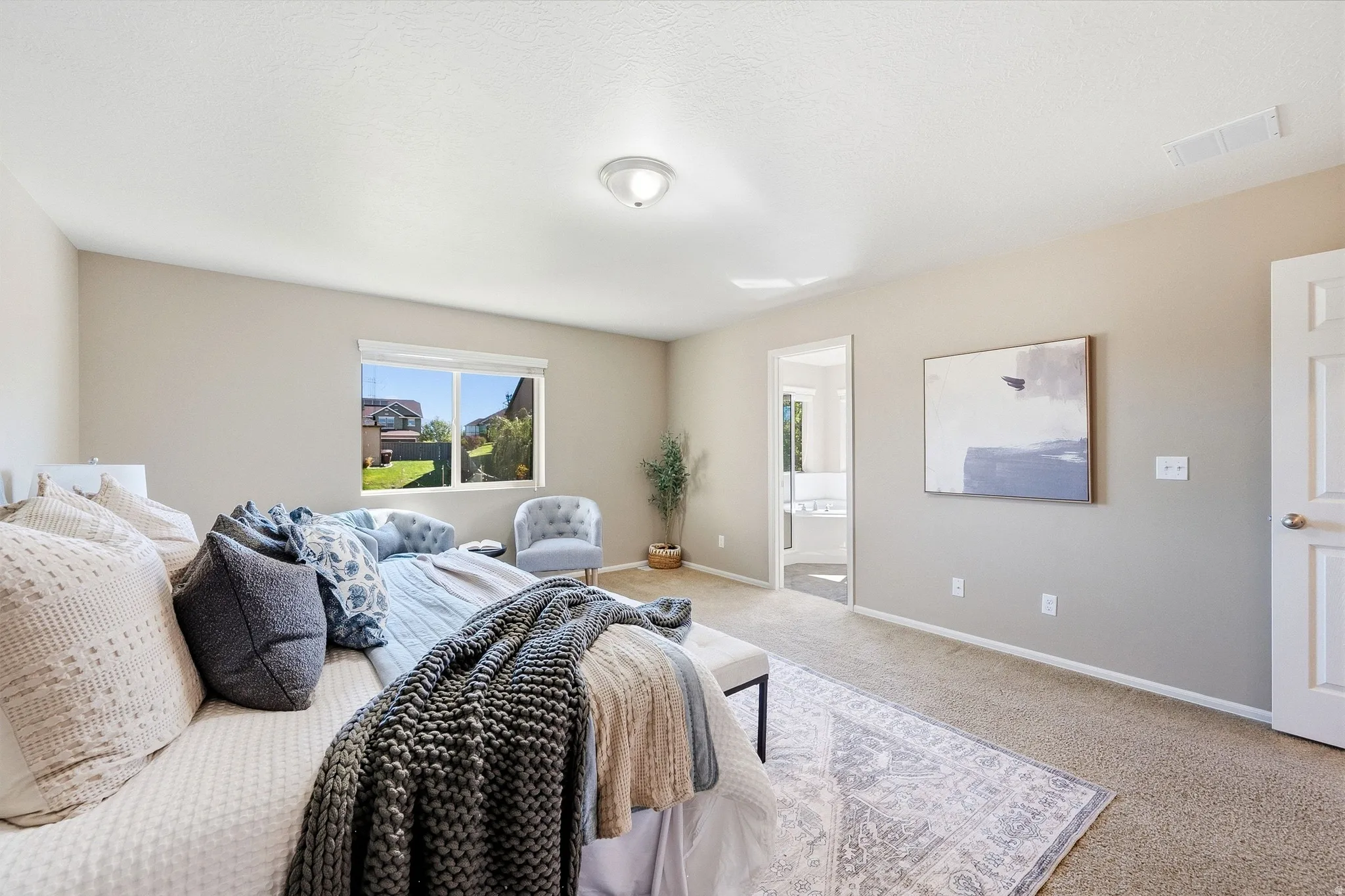 Neutral wall tones, carpeted flooring, a recessed window, and an open doorway reveal a built-in tub