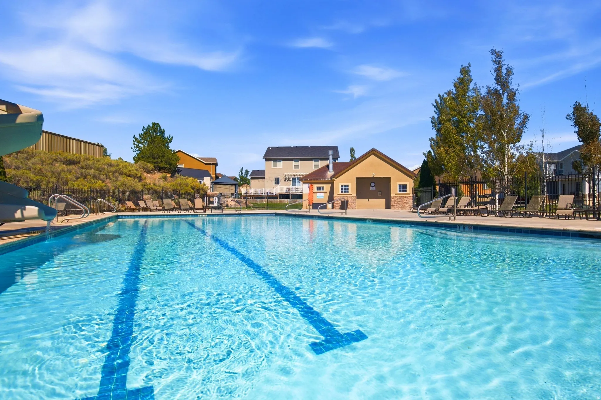 Expansive swimming pool featuring lane lines and surrounding hardscaping