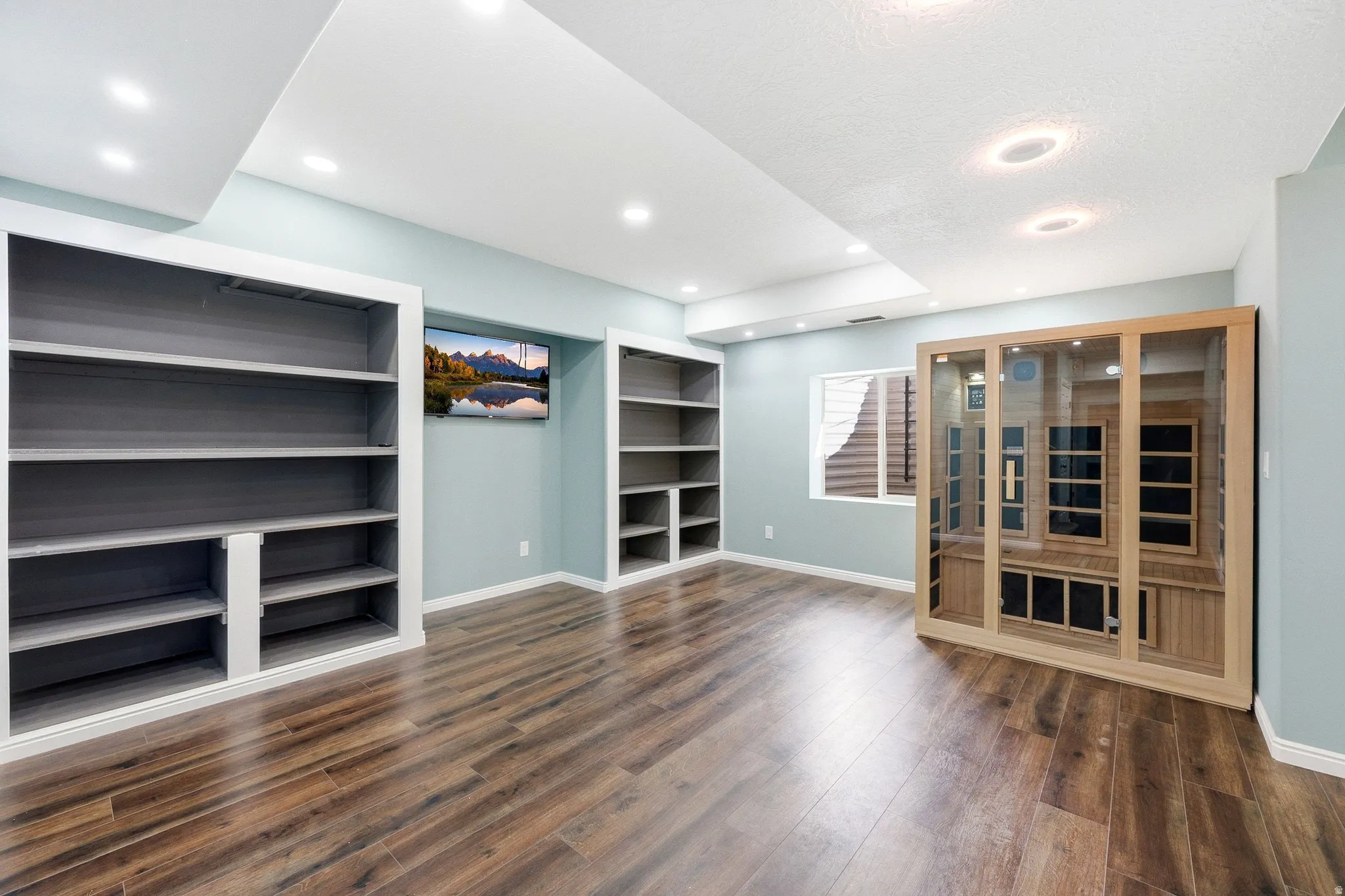 Wood-finish flooring, recessed lighting, and built-in shelving units