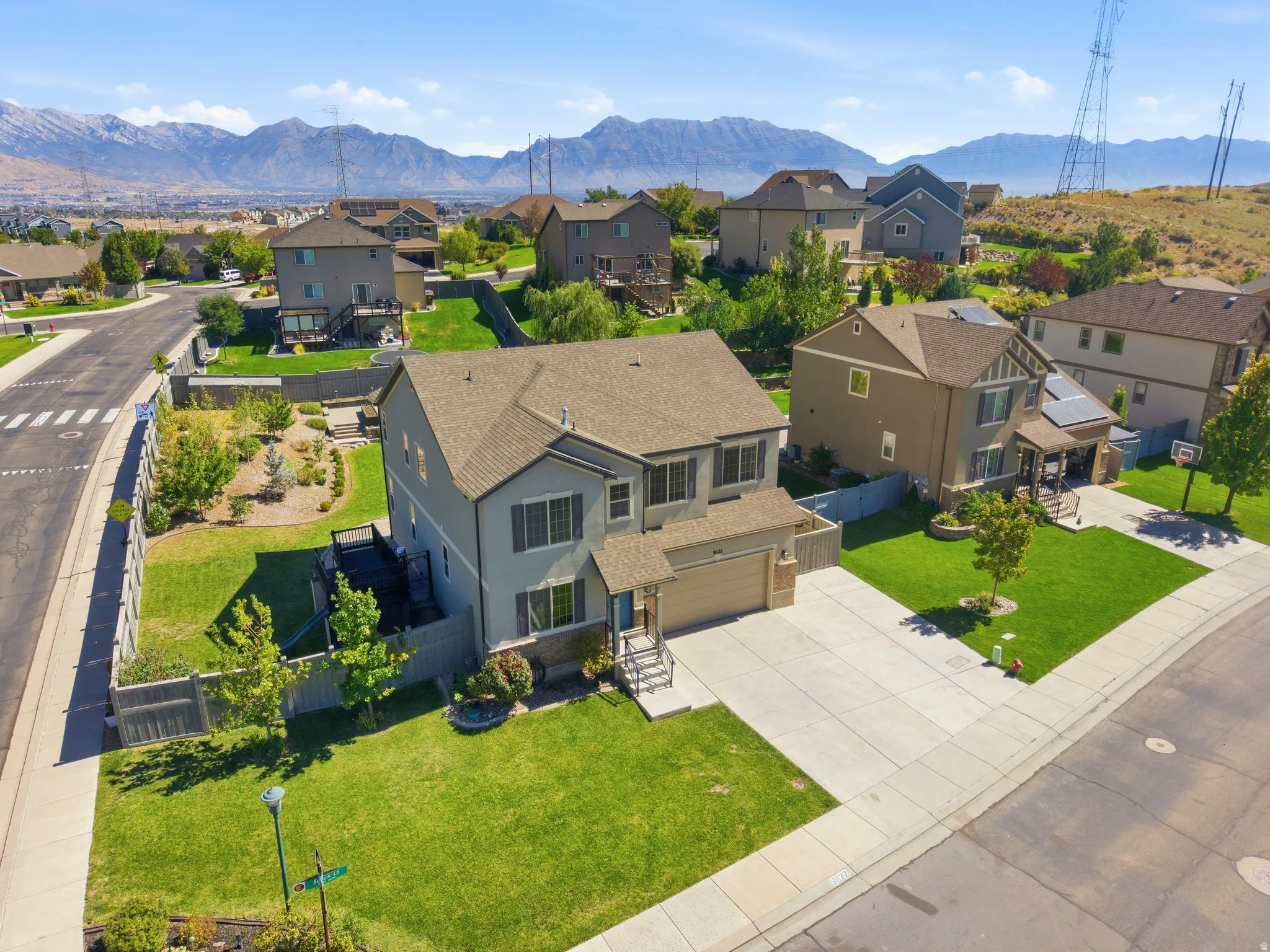 Multi-story residence featuring a two-car garage, front yard landscaping, and a fenced backyard