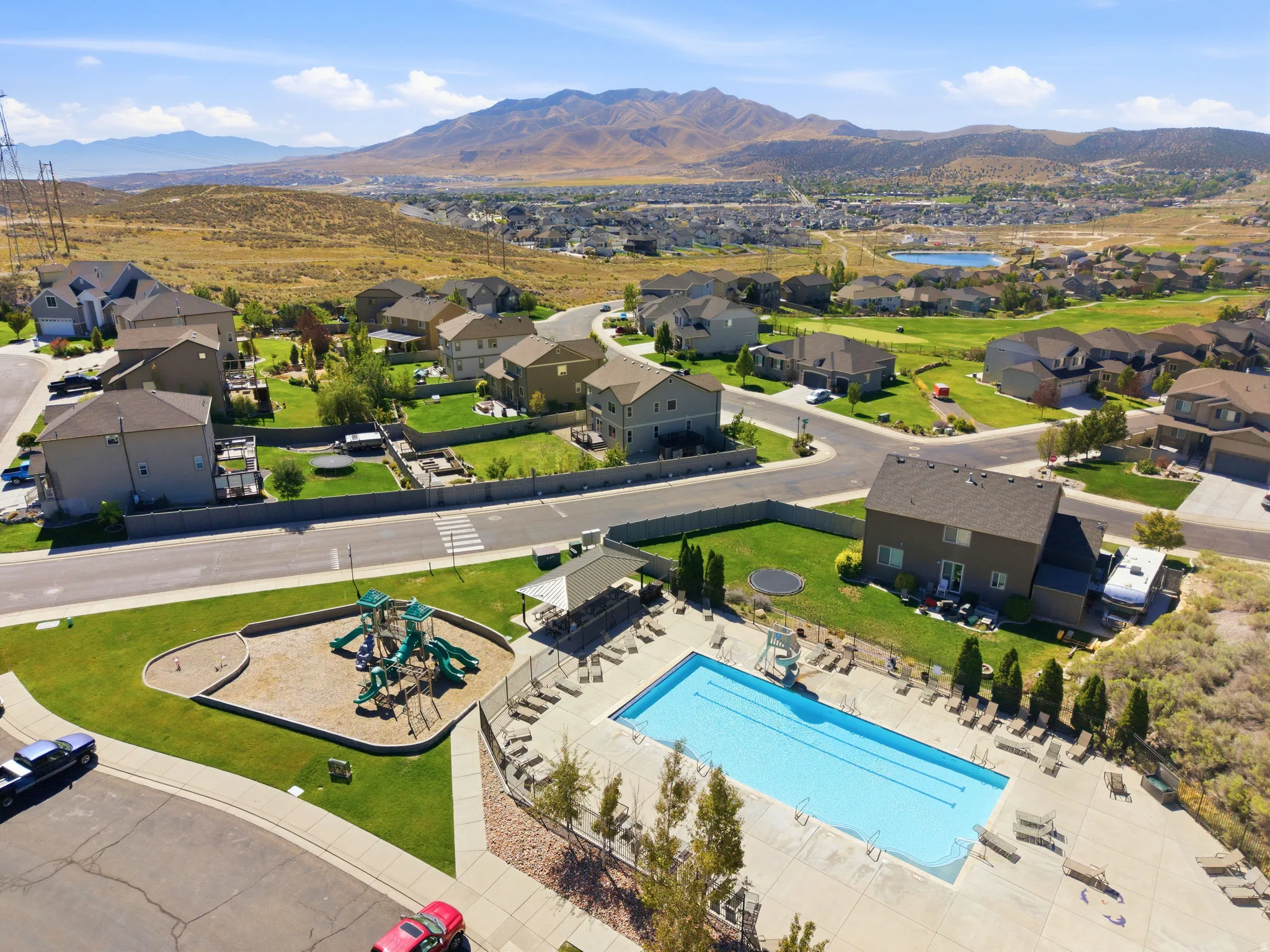 Community amenities featuring a swimming pool, playground, and mountain backdrop