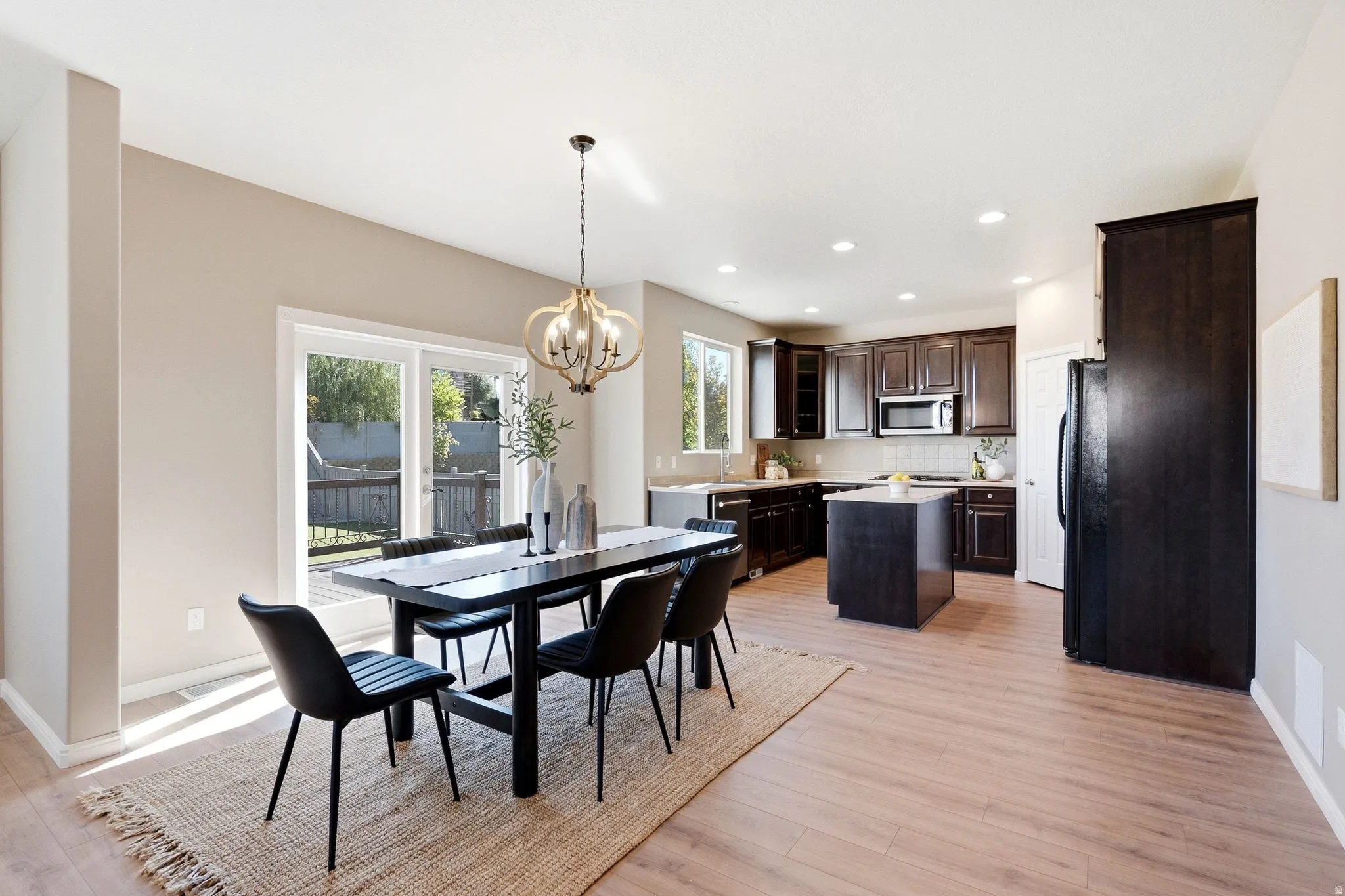 Wood-finish flooring throughout, with a contemporary chandelier in the dining area