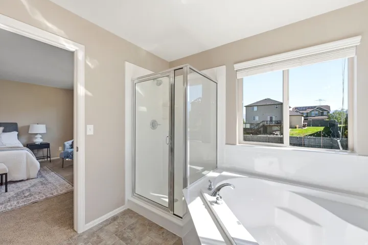 Built-in soaking tub, glass-enclosed shower, expansive window, and durable flooring