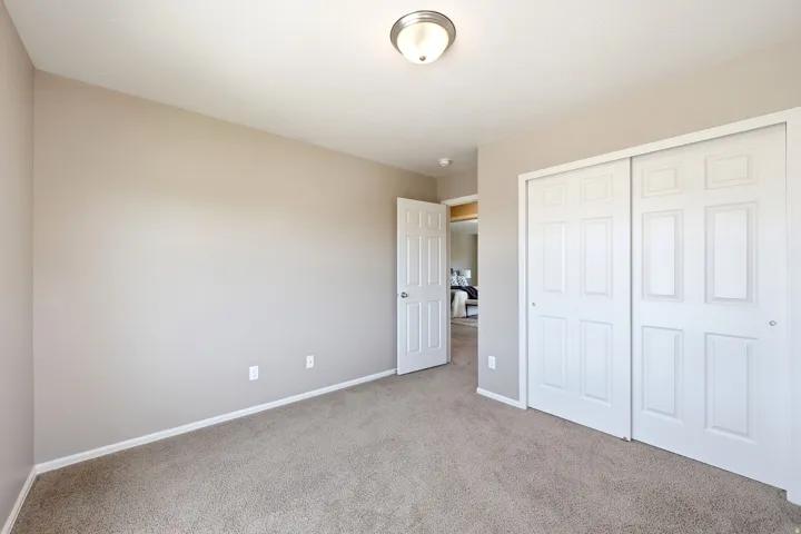 Neutral-toned walls complement the carpeted flooring