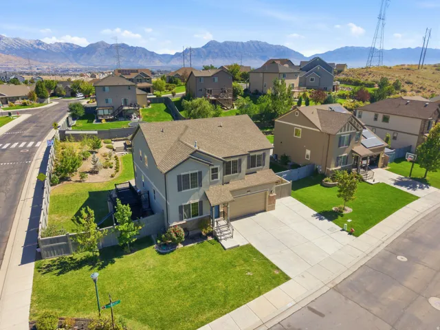 Multi-story residence featuring a two-car garage, front yard landscaping, and a fenced backyard